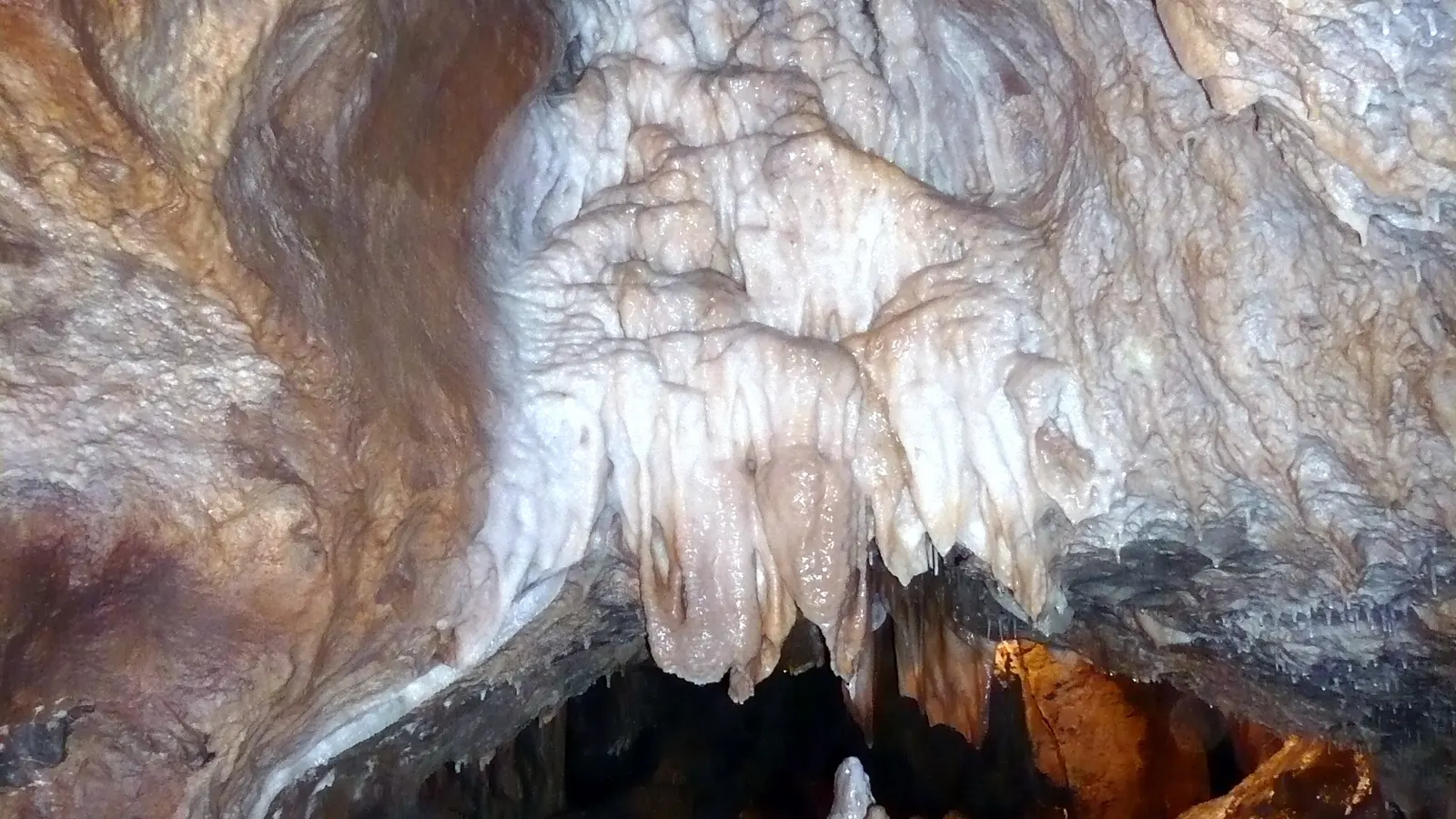 Sinterfahnen und Tropfsteine an der Decke eines Saals der Atta-Höhle