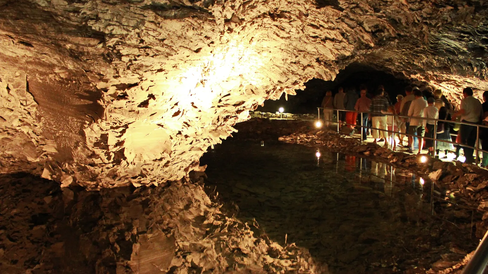 Beleuchteter Saal der Barbarossahöhle, der sich in einem der unterirdischen Seen spiegelt