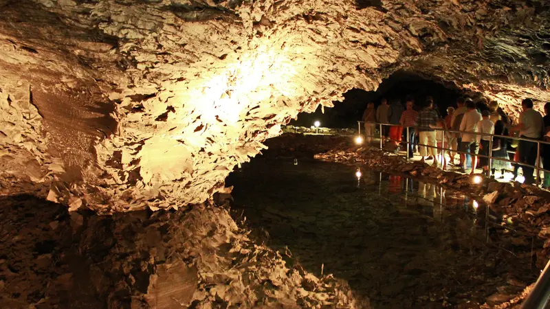 Beleuchteter Saal der Barbarossahöhle am Kyffhäuser, der sich in einem der unterirdischen Seen spiegelt
