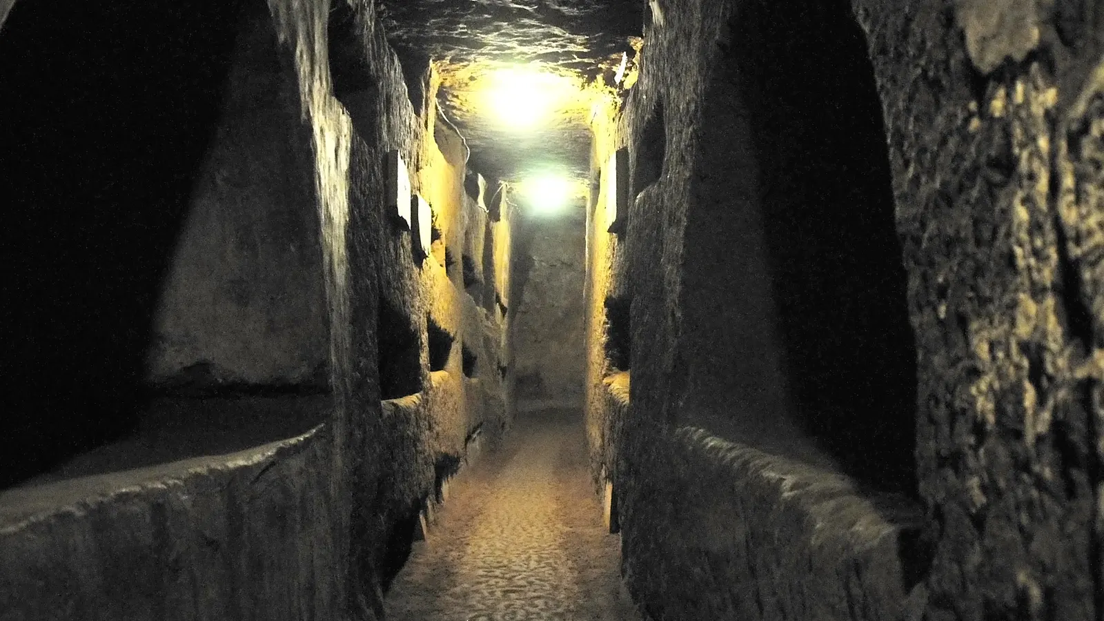 Schmaler Gang mit Grabnischen in den Domitilla-Katakomben in Rom
