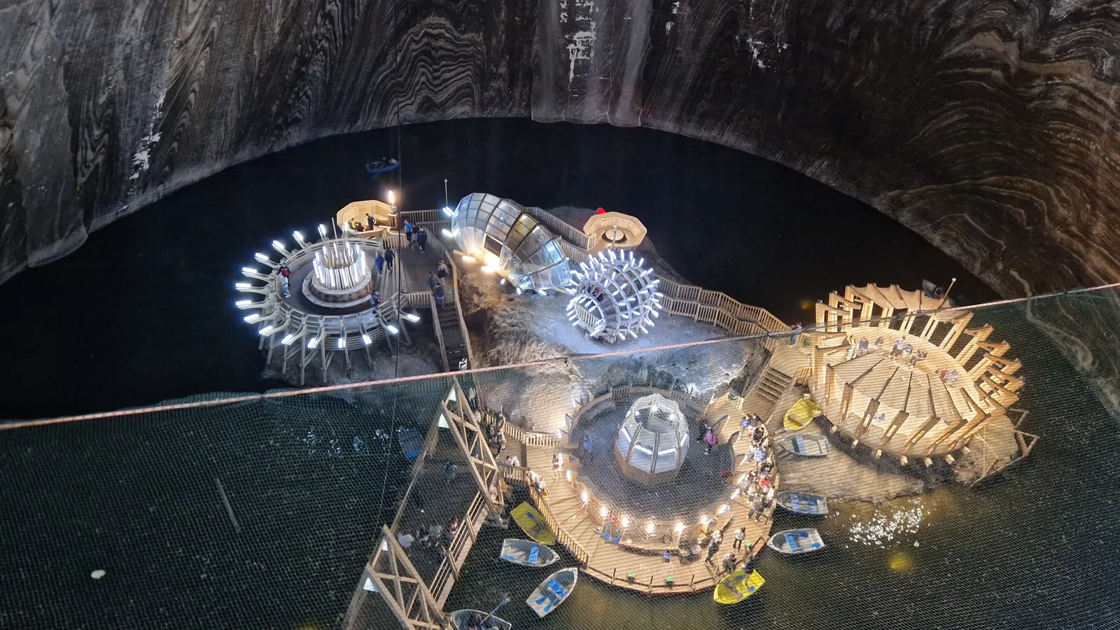 Beleuchtete Plattformen und Ruderboote auf dem unterirdischen See der Terezia-Kammer in der Salina Turda